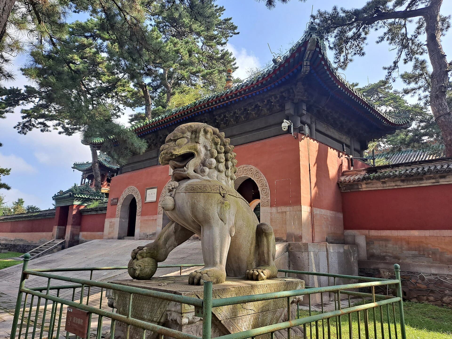 Stone lion, gate and roofline at Pule Temple