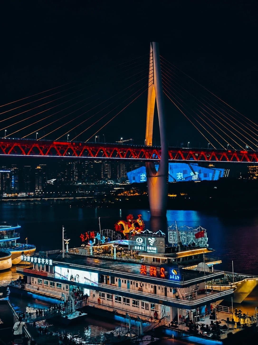 Vista nocturna de Hongya Cave con cruceros y el puente Qiansimen