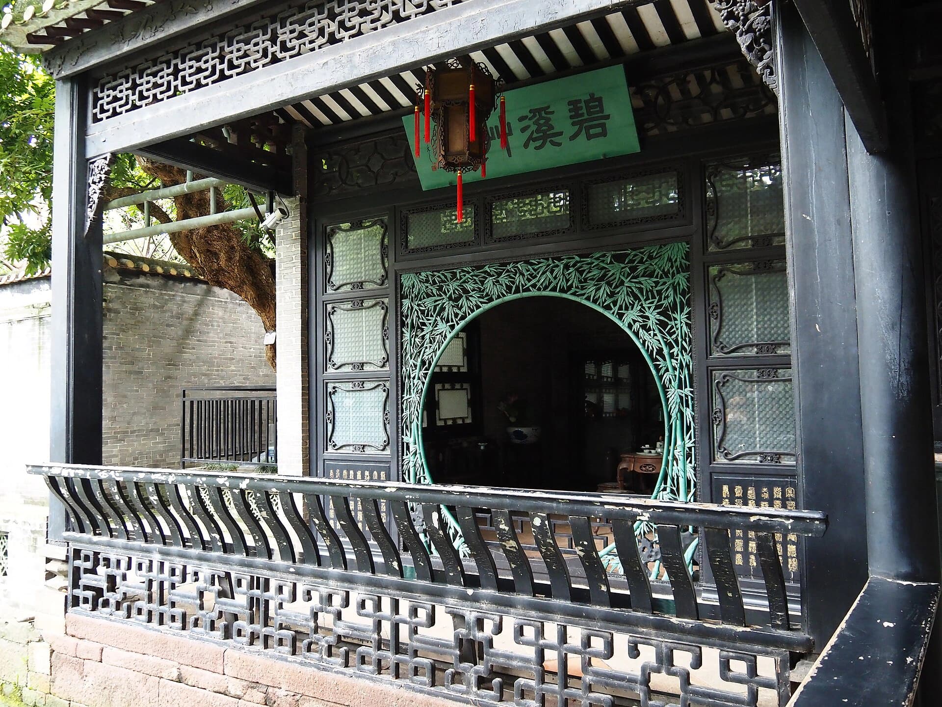 Decorative window framing a view inside Qinghui Garden