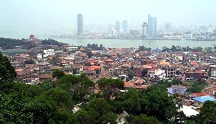 Tejados superpuestos de Gulangyu y paisaje subtropical de la isla