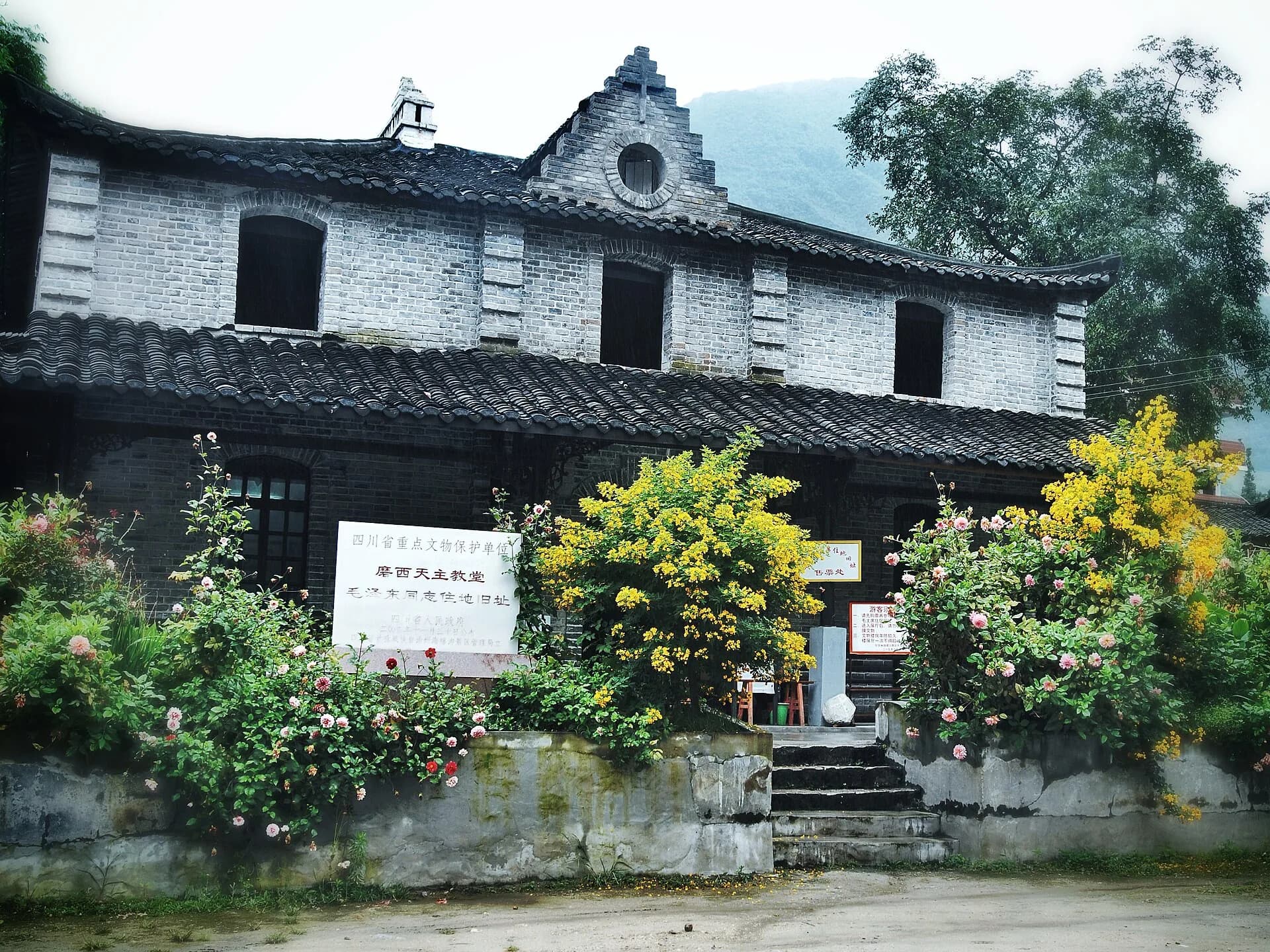 Catholic church facade and flowers in Moxi town near Hailuogou