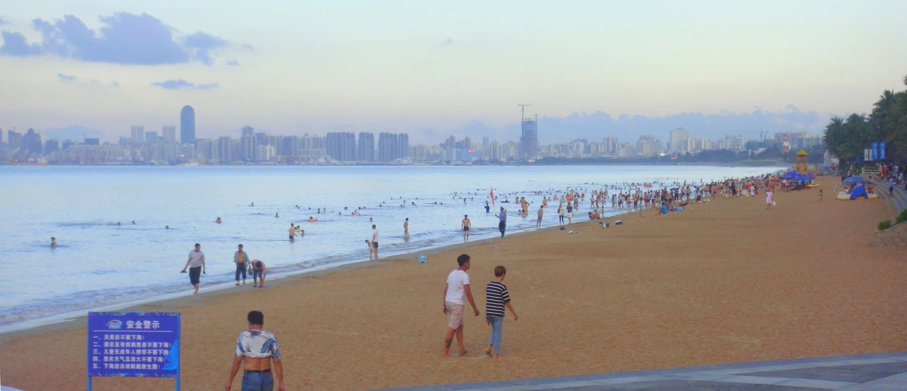 Visitantes y amplia línea de costa en Holiday Beach, Haikou