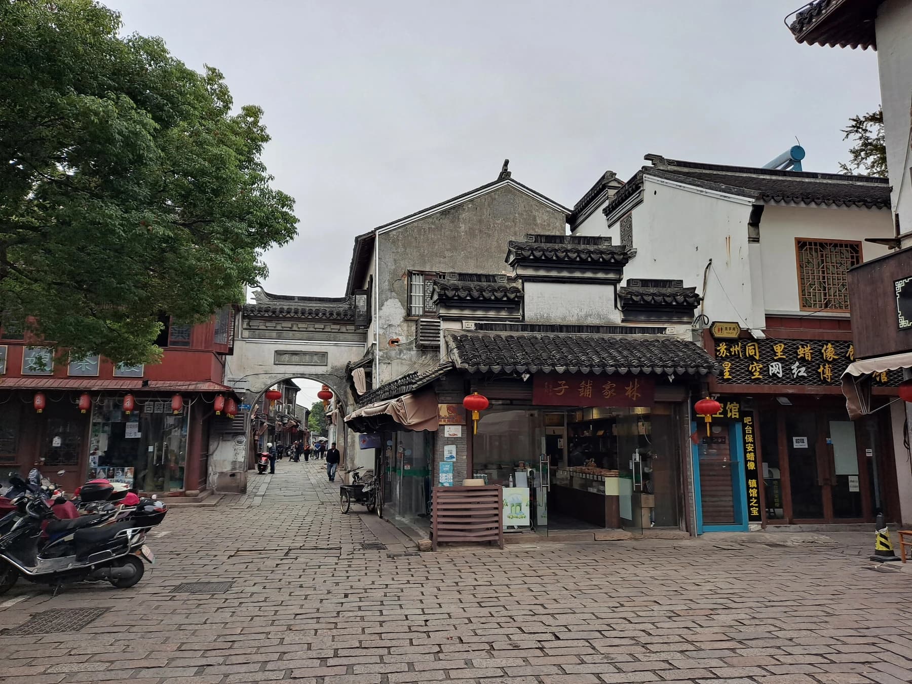 Callejuela cotidiana, tiendas y casas de paredes blancas dentro de Tongli