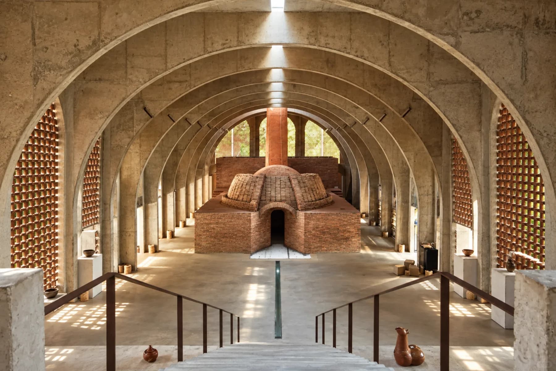 The brick wood kiln beneath Bingding's repeating concrete vaults and central skylight