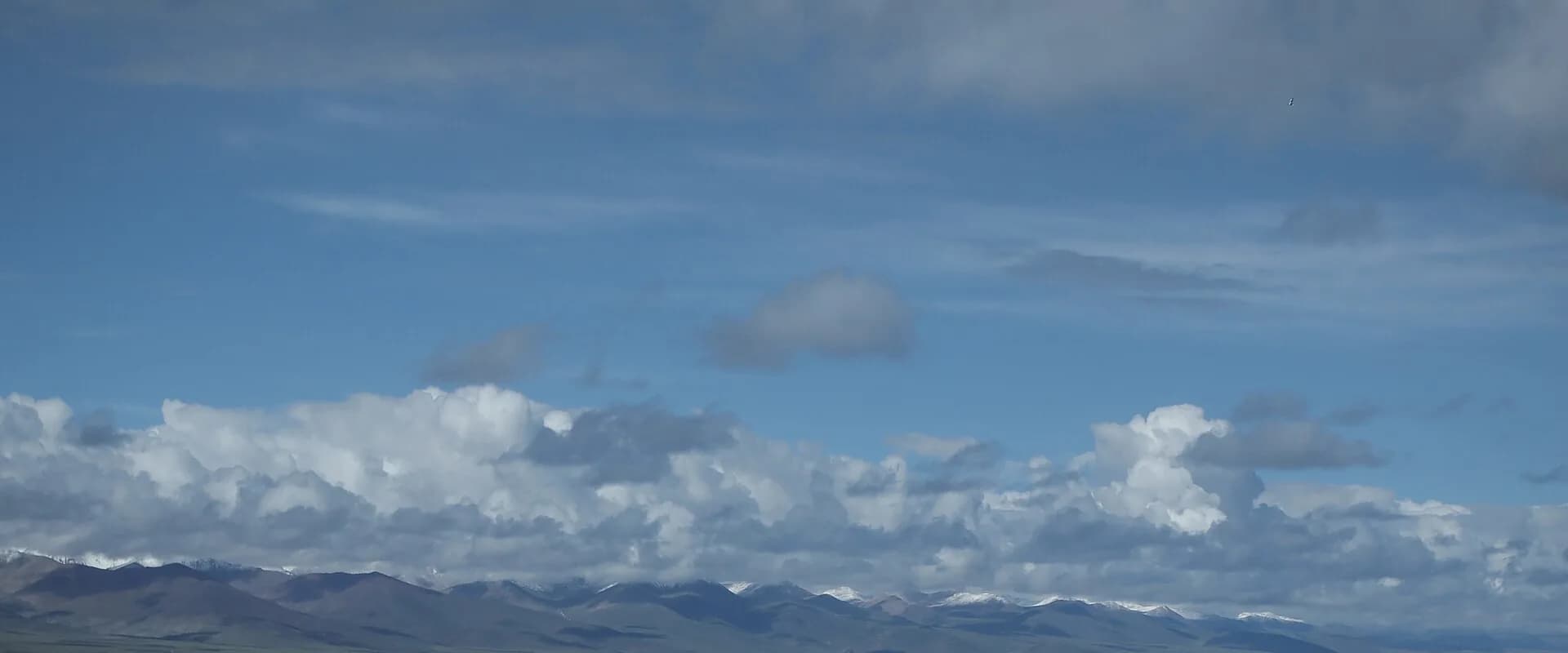 landscape of Namtso Lake, clouds and distant mountains