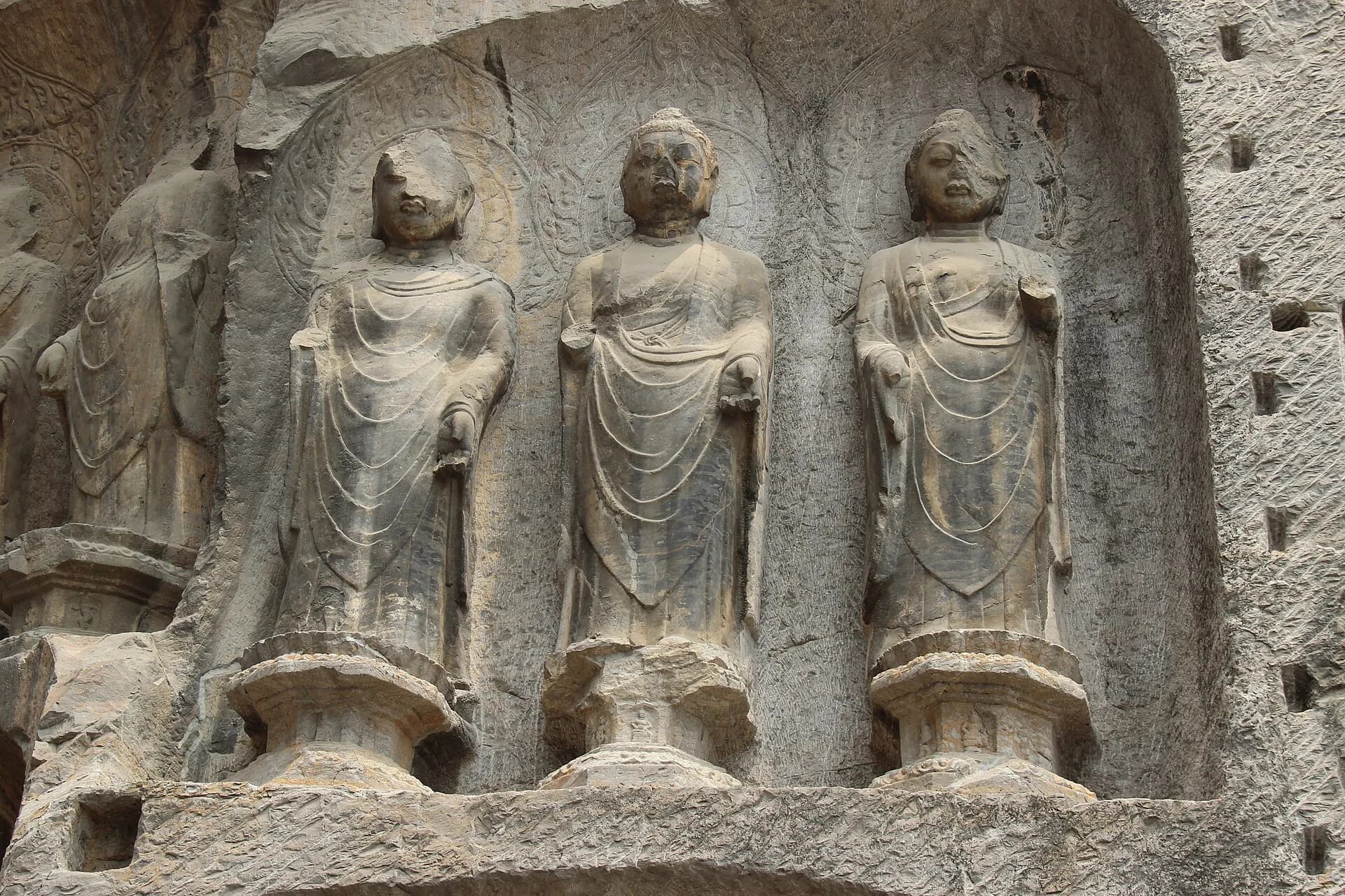 People-free detail of weathered Buddhist sculptures at Longmen Grottoes