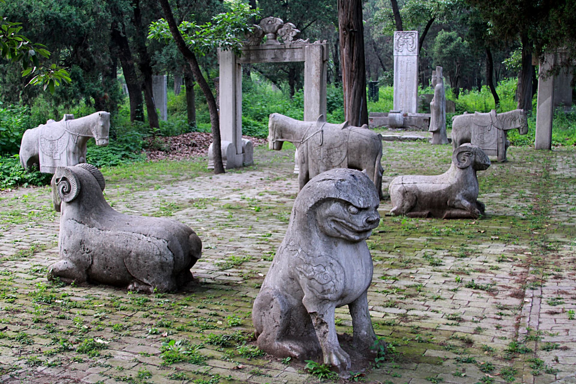 Figuras de piedra en un camino arbolado del Cementerio de Confucio
