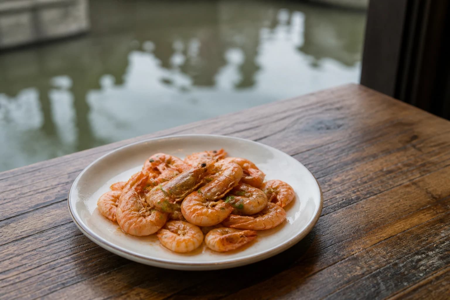 Un modesto plato de camarones de río al estilo local junto a un canal borroso
