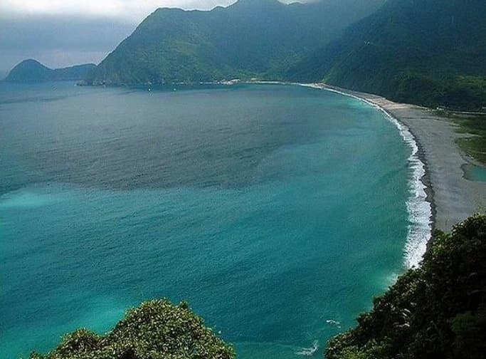 Playa curva y promontorio verde en Dong'ao Island, Zhuhai