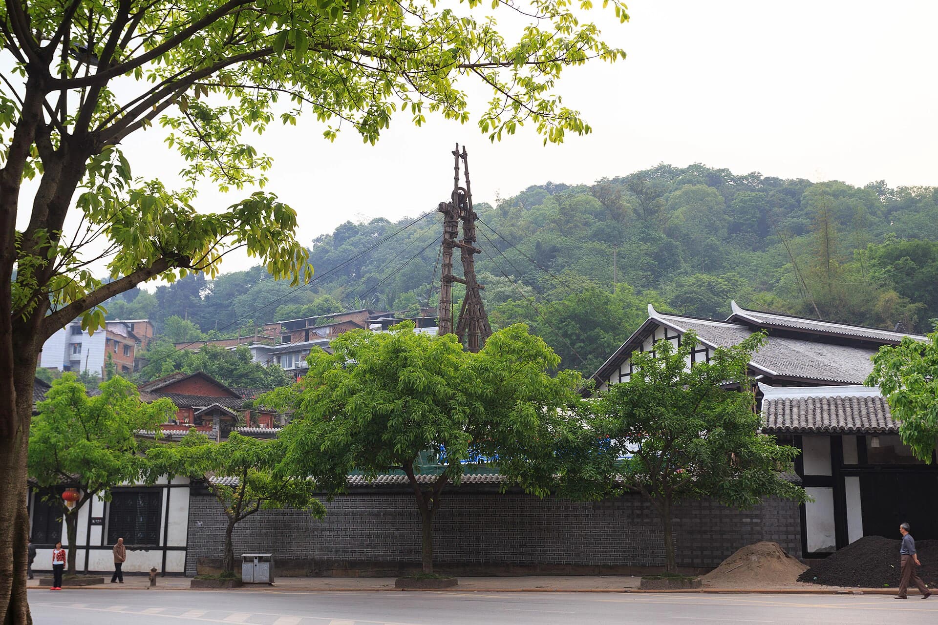 Tall wooden derrick rising above the Shenhai Well compound in Zigong