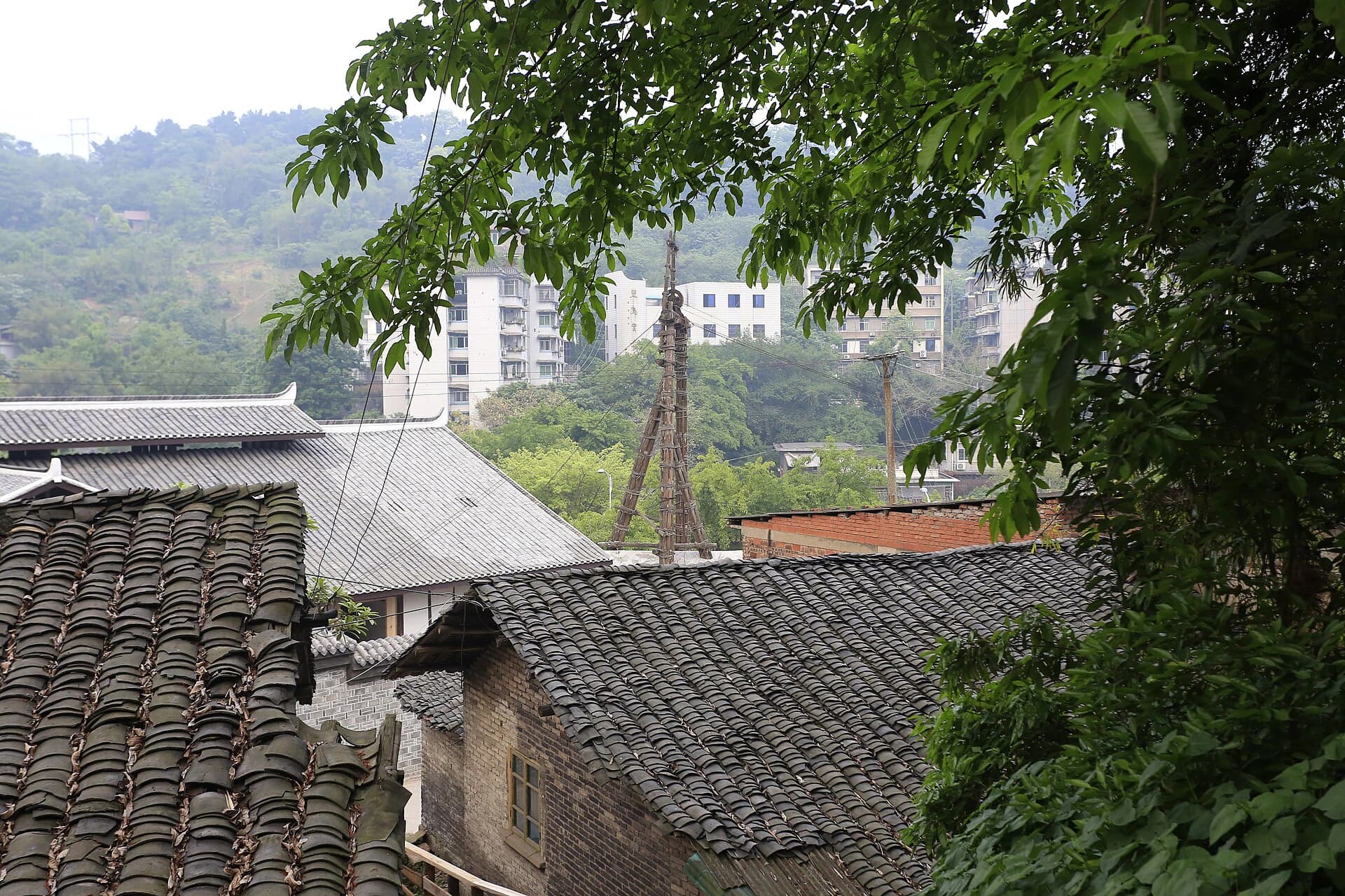 Historic rooftops and the wooden derrick within the Shenhai Well site