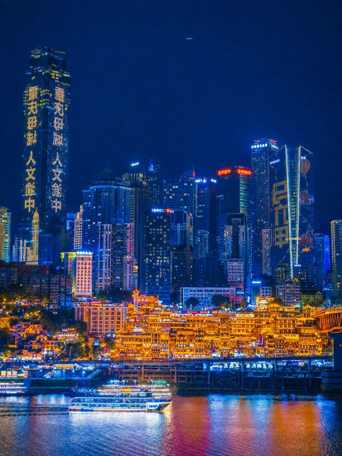 Vista nocturna del Gran Teatro de Chongqing con el puente Qieshimen y Hongyadong