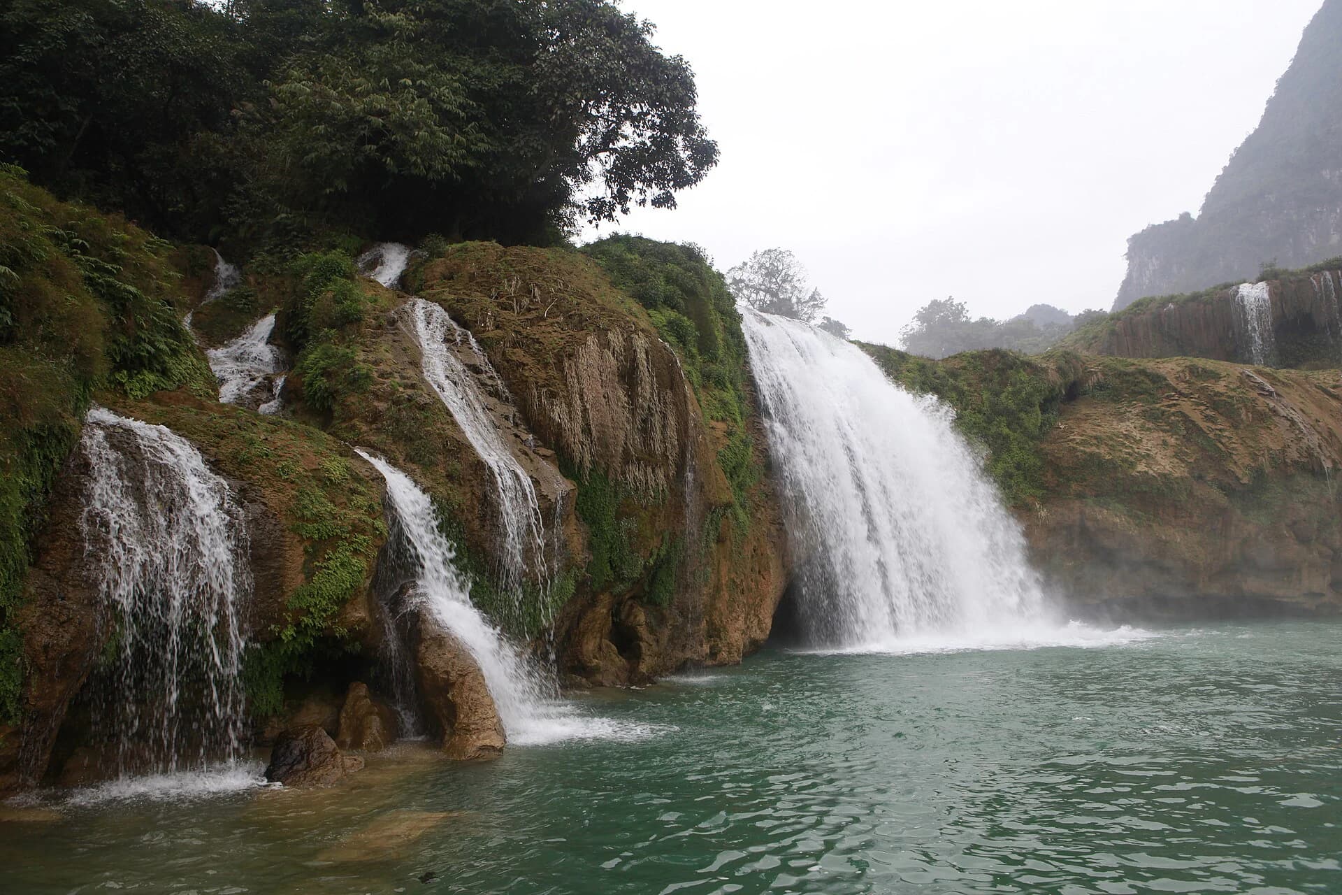 Multiple green-season tiers of Detian Waterfall beside karst cliffs