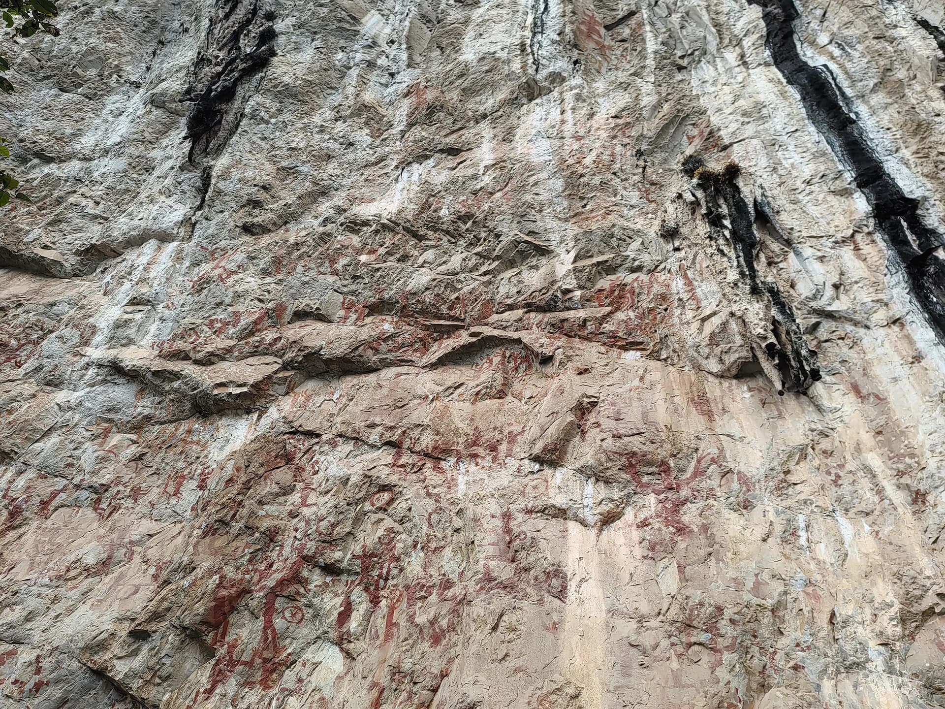 Broad section of the Huashan cliff covered with ochre rock-art figures