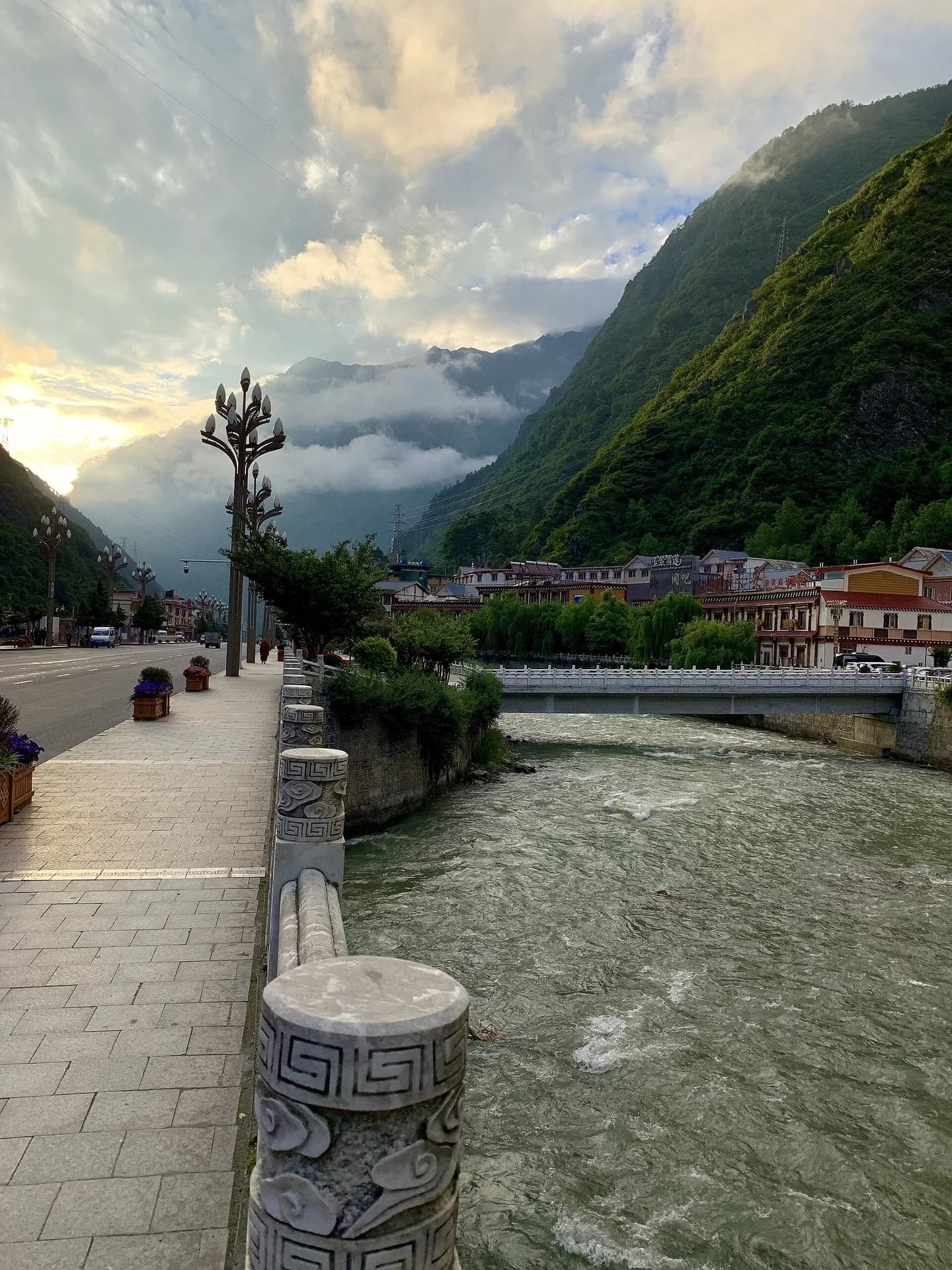 Buildings and mountain slopes framing the river through central Kangding