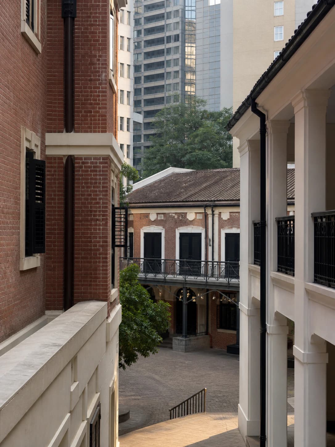Vista de un tranquilo patio patrimonial de ladrillo rojo inspirado en el centro de Hong Kong