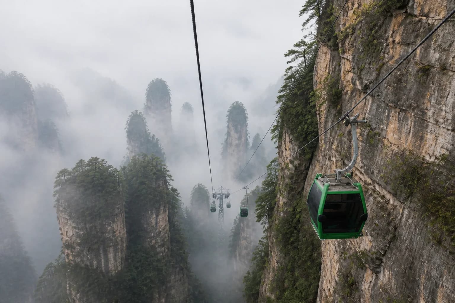 Vista del teleférico de Huangshi Village junto a brumosos acantilados de arenisca de cuarzo