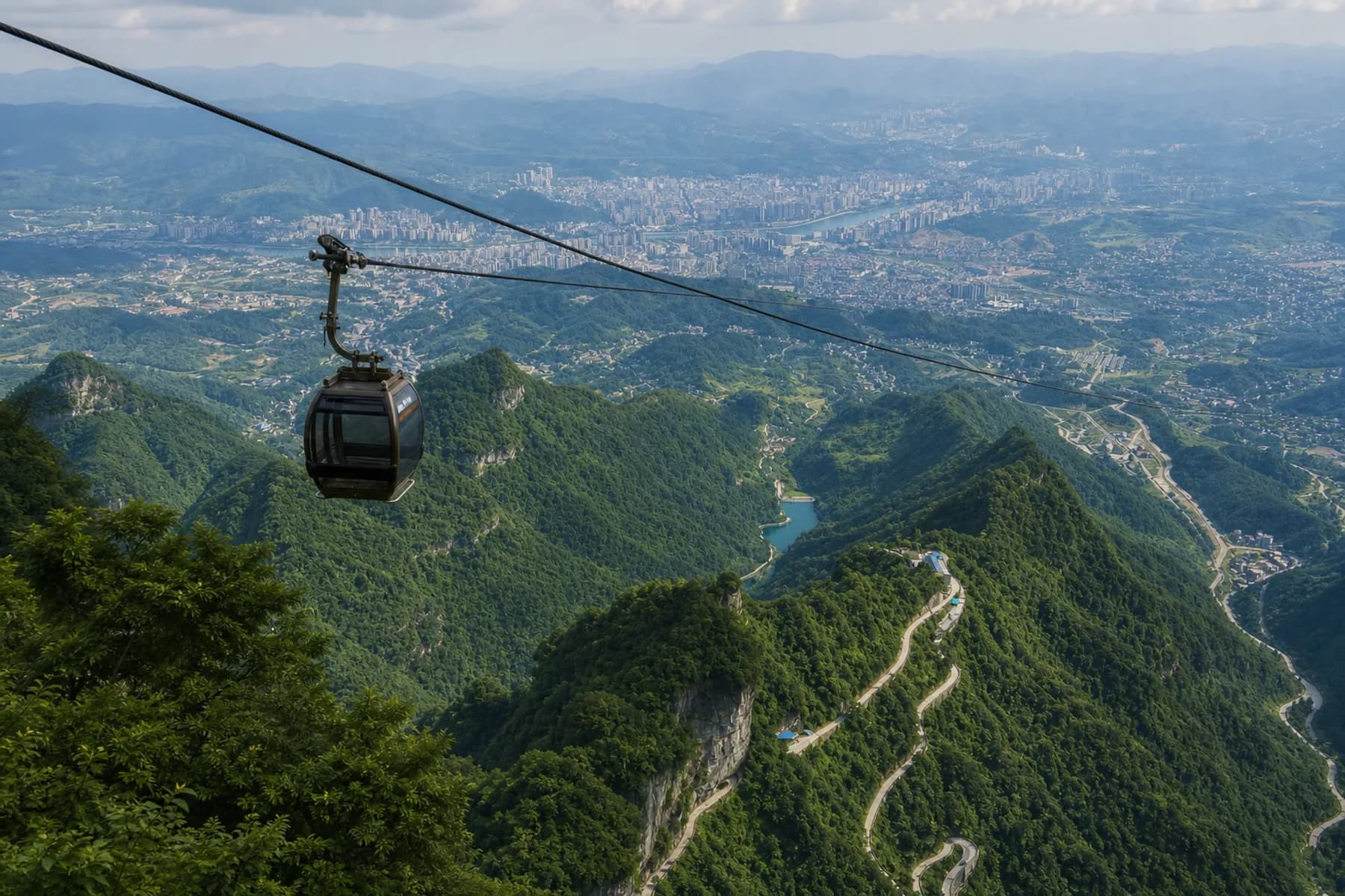Panorama de un teleférico de Tianmen, la carretera de montaña y la ciudad de Zhangjiajie debajo