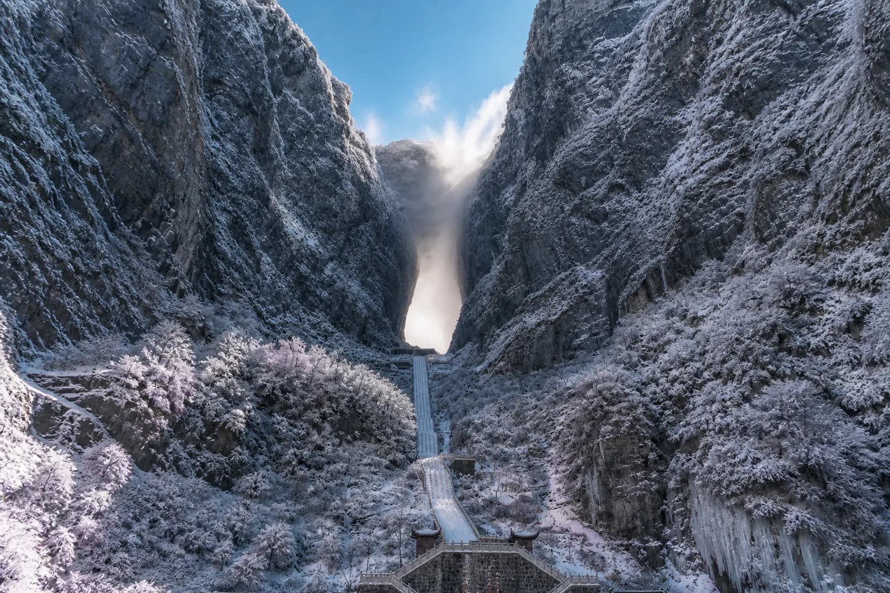 Vista invernal de la cueva de Tianmen, los acantilados helados y la escalera cubierta de nieve