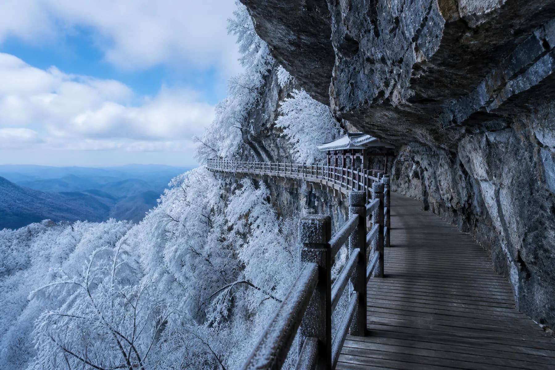 Vista invernal a lo largo de un paseo de tablones helado junto al acantilado de la montaña Tianmen