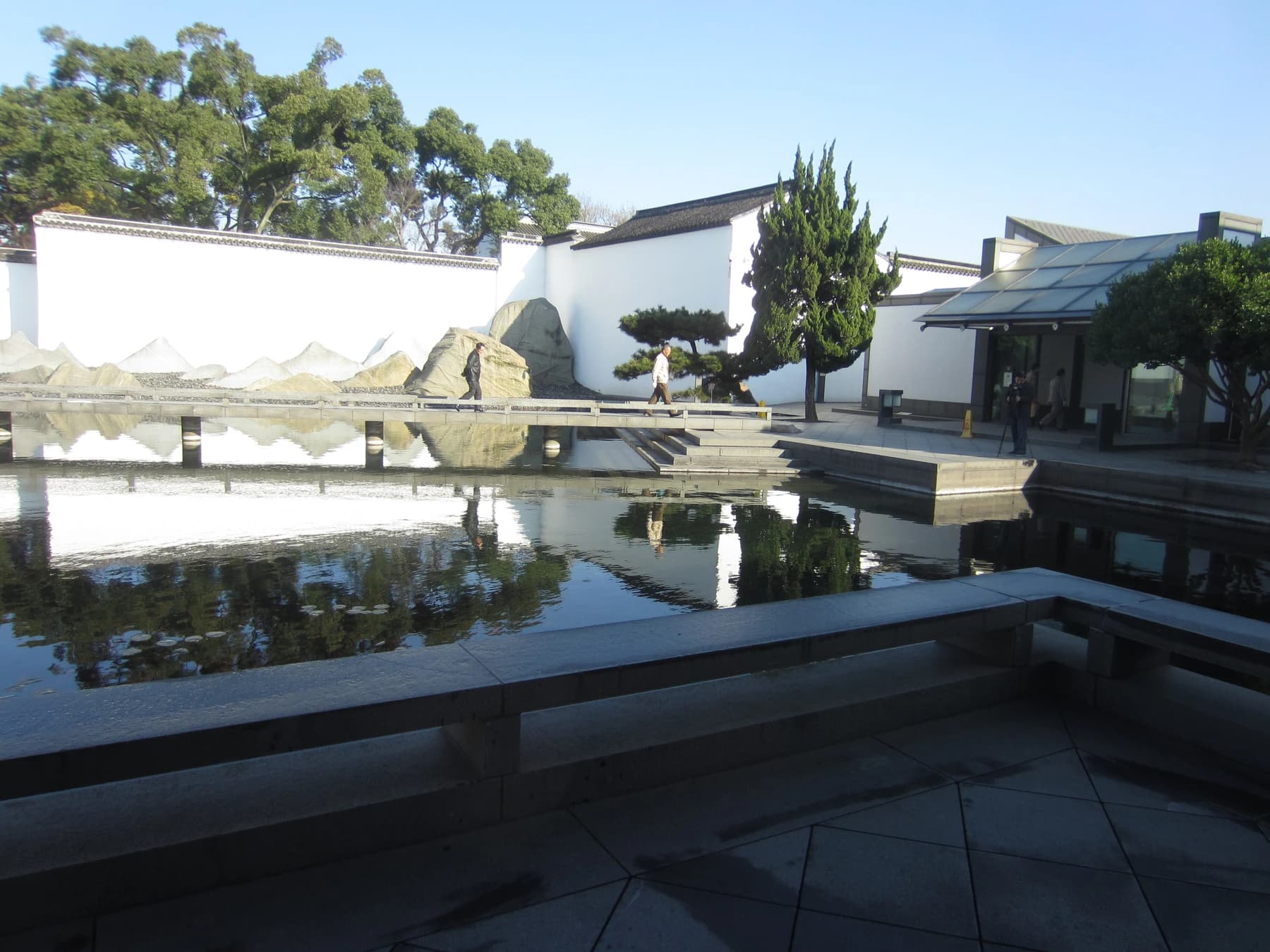 Patio geométrico, estanque y pared blanca en el Museo de Suzhou