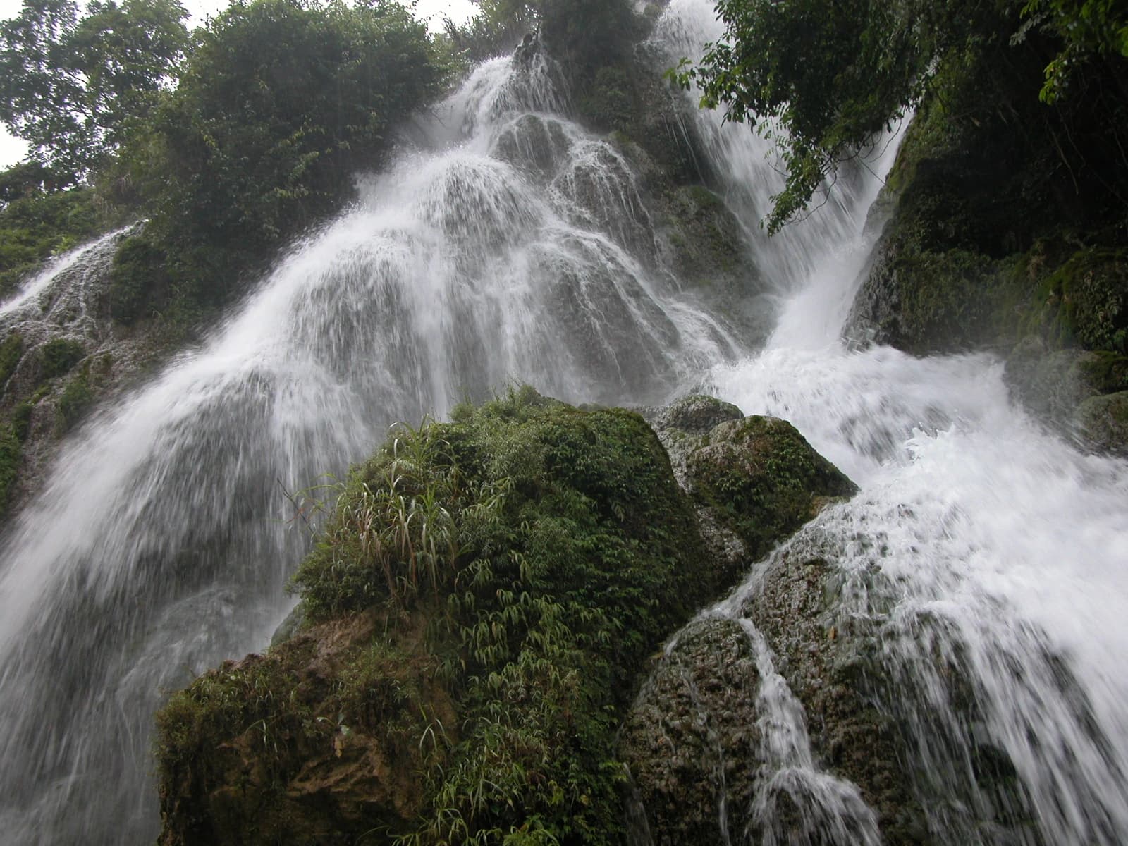 La cascada Laya cae por una ladera caliza cubierta de bosque en Xiaoqikong