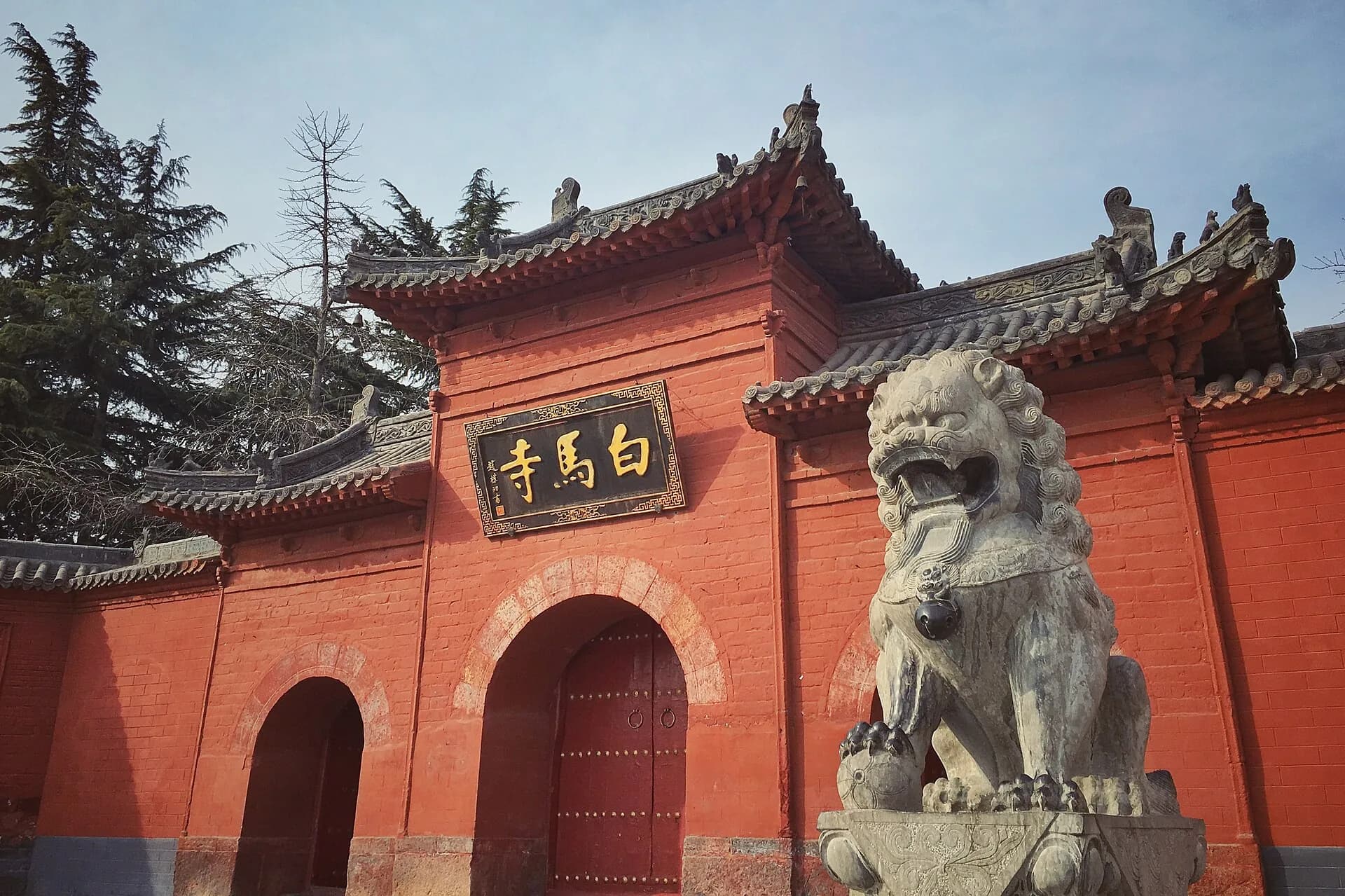Vista del shanmen rojo y el león de piedra de White Horse Temple