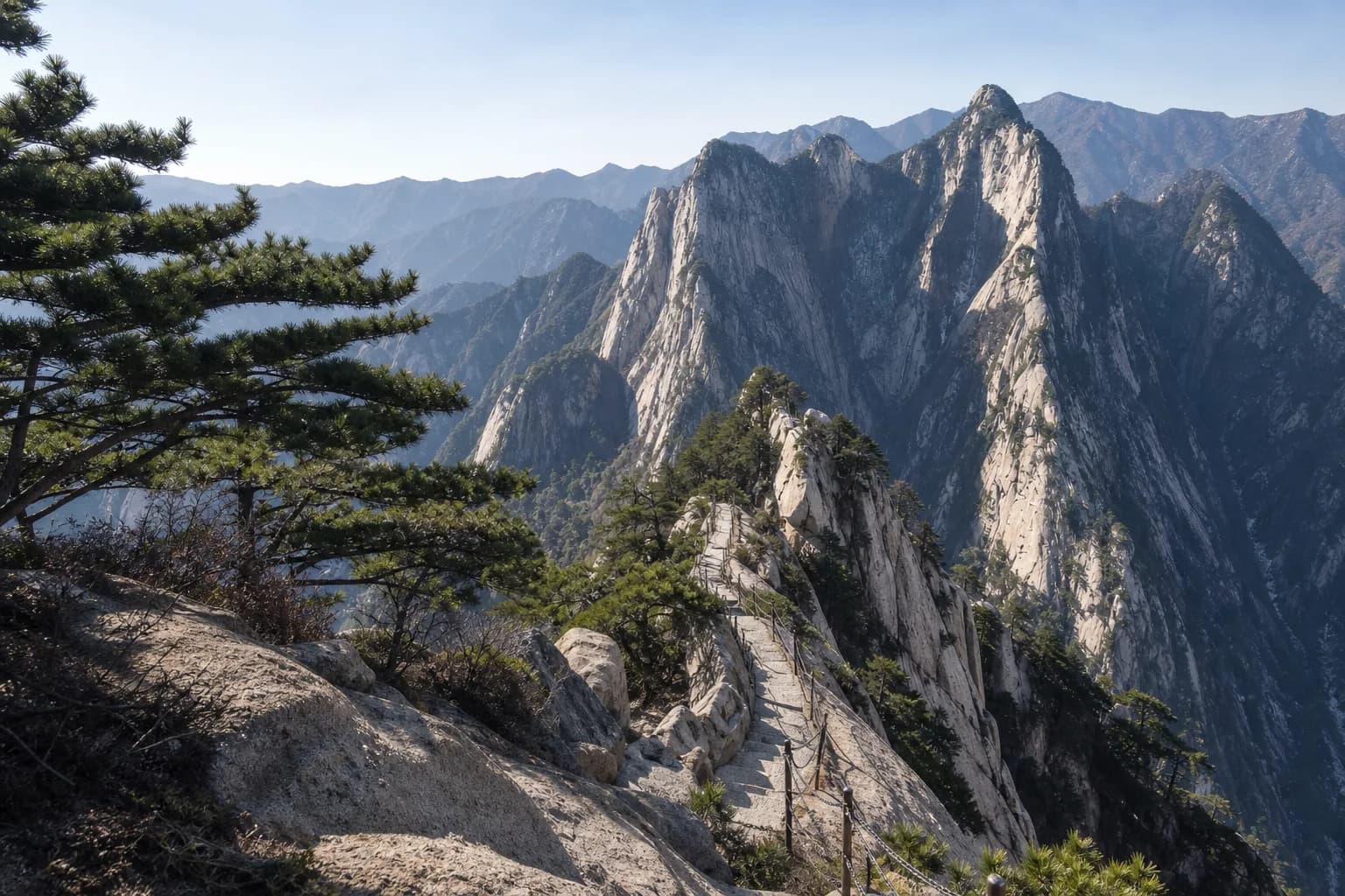 Sendero de cresta de piedra mantenido y picos de granito en el Monte Hua