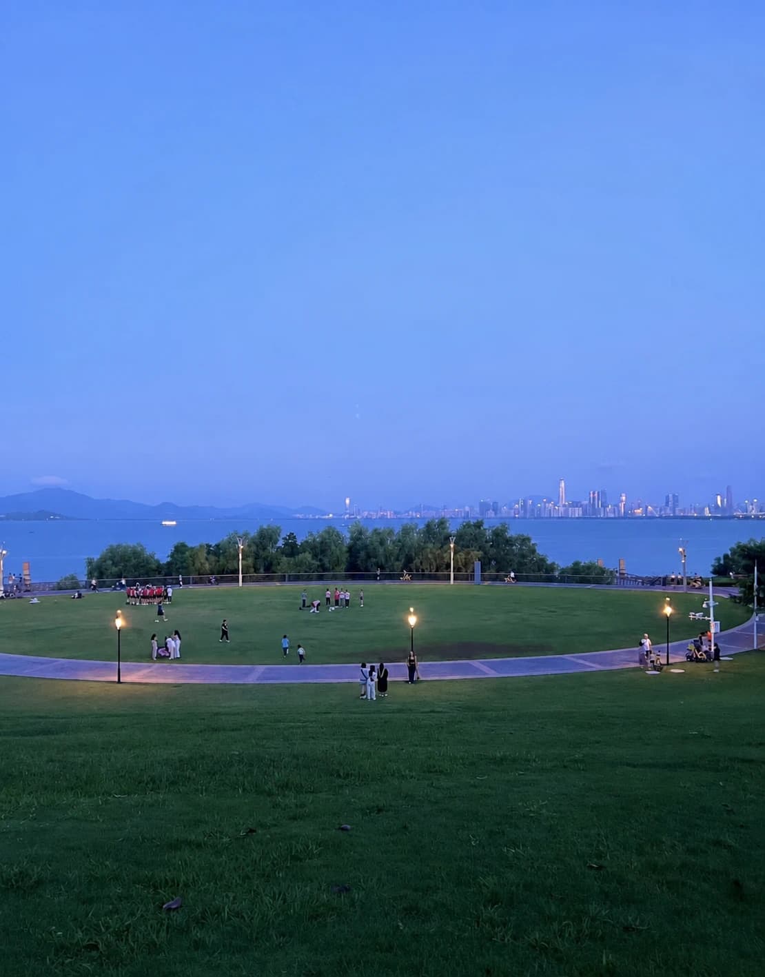 Shenzhen Bay Park por la noche con el césped y el paseo marítimo iluminados