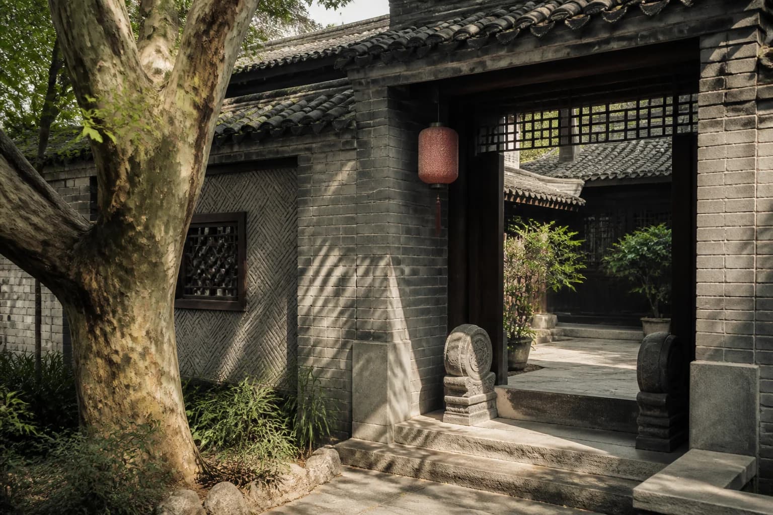 Detalle de un portón de patio de Chengdu en ladrillo gris, tejas oscuras, celosía de madera y plátano de sombra