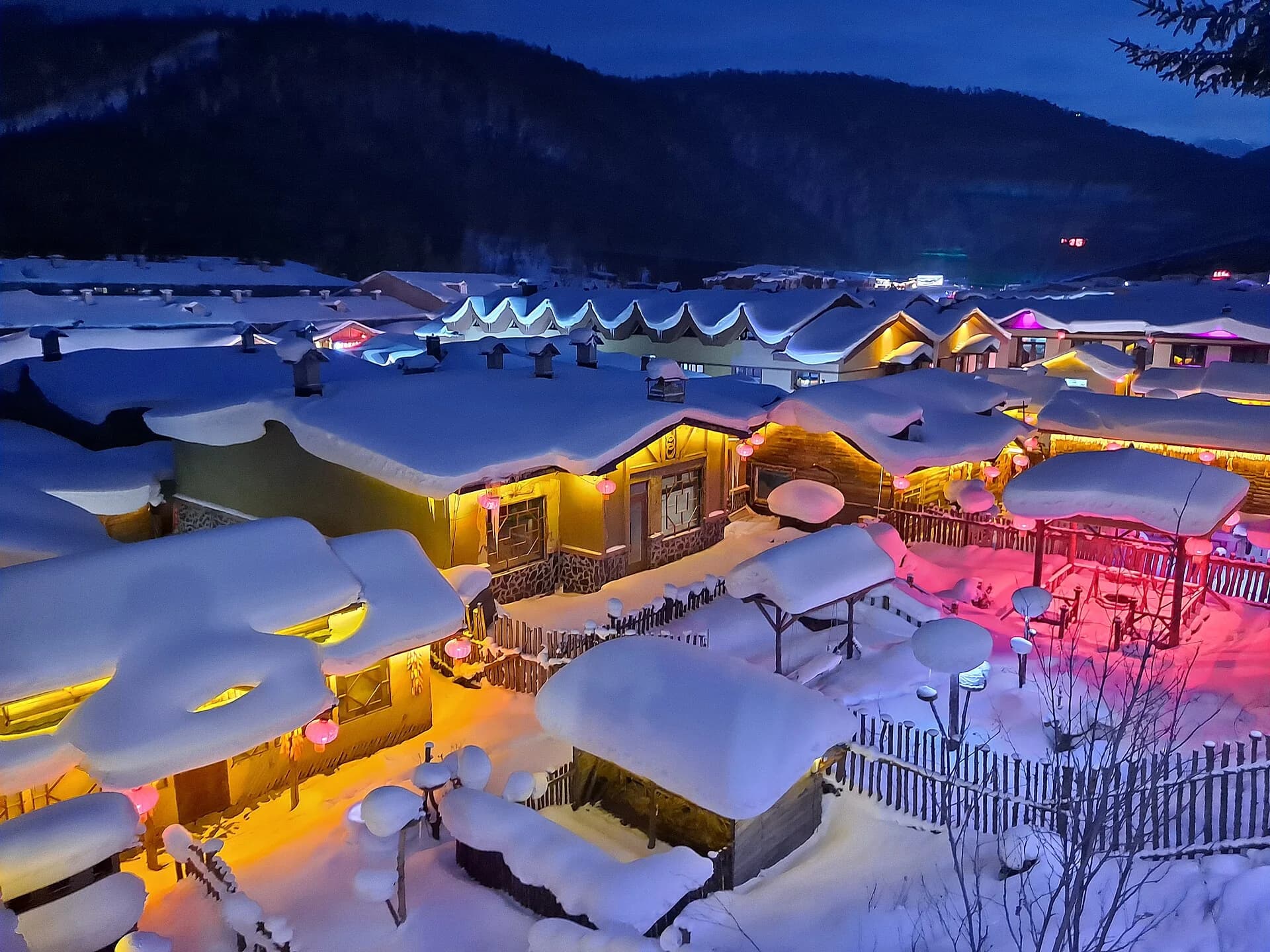 Snow-covered village roofs illuminated at night in China Snow Town