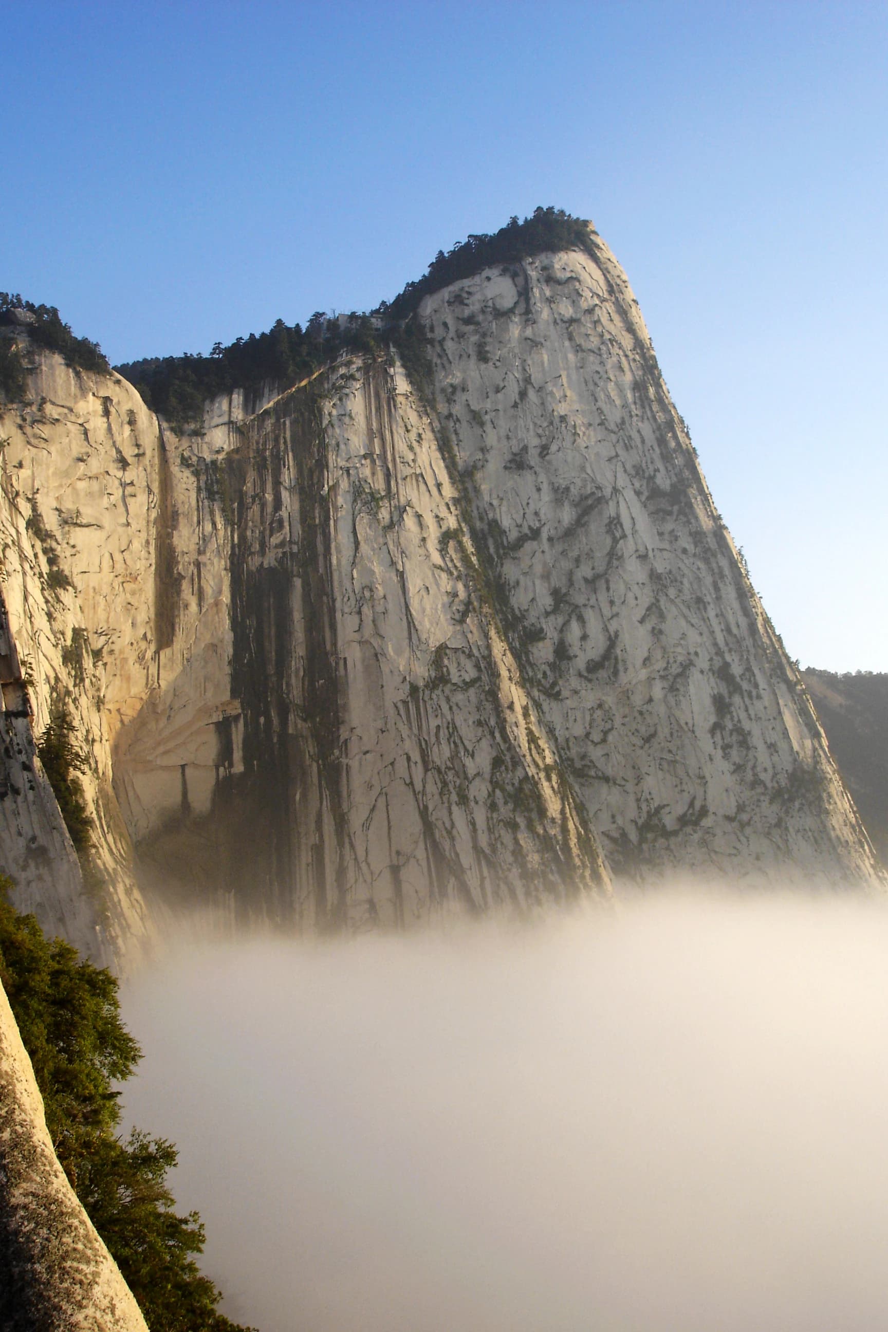 Paredes graníticas sobre una capa de nubes en el lado occidental del monte Hua