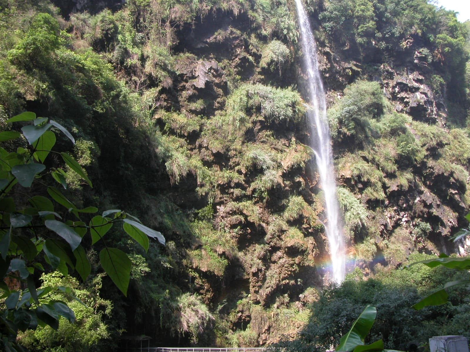 A narrow waterfall dropping into Maling River Canyon with spray and a faint rainbow