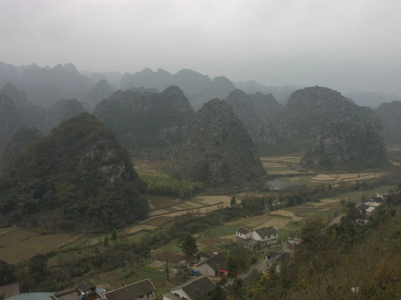 Wanfenglin's cone-shaped peaks and fields fading into low cloud