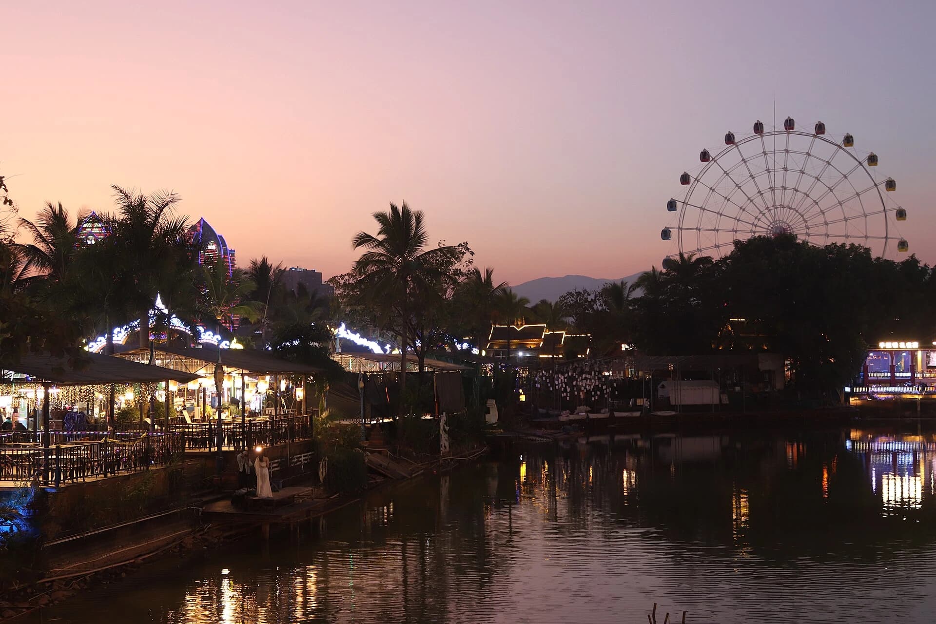 Evening lights reflected on water in Jinghong's tourist district