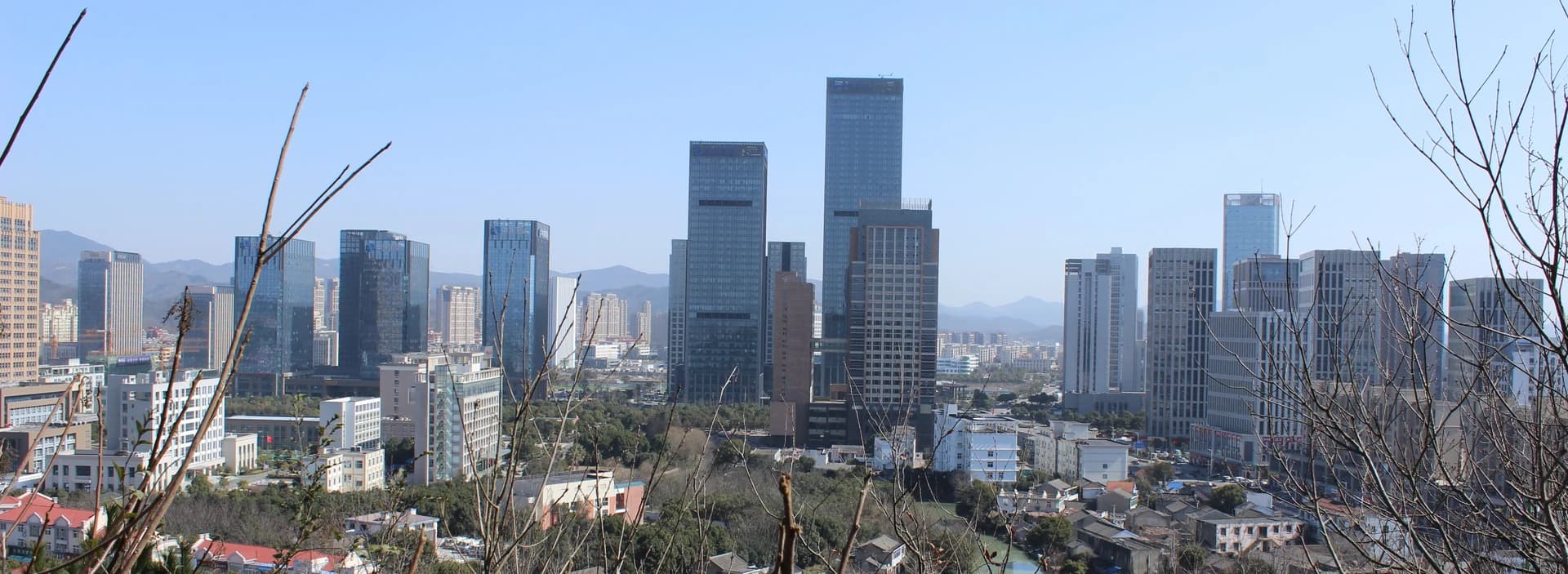 Zhoushan new-city skyline between green hills